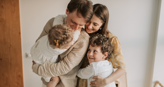 family of four hugging